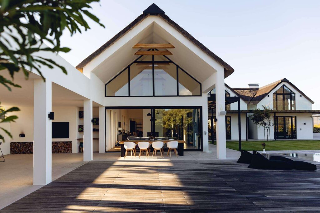 View of luxurious modern house exterior with dining area, representing services offered by trusted real estate agents in the United States